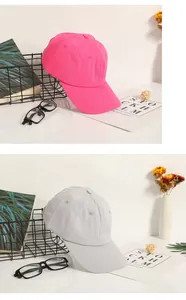 Detailed close-up of pink and grey cotton baseball caps with breathable eyelets