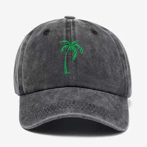 Washed dark gray baseball cap with green coconut tree embroidery on plain background
