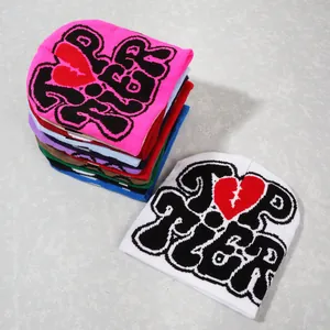 Close-up of colorful Y2K knit beanies with Top Tier lettering and heart jacquard detail