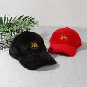 Détail de casquettes de baseball en peluche avec broderie soleil et texture douce