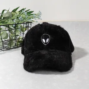 Close-up of alien embroidery on soft black plush baseball cap for winter warmth