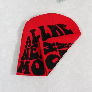 Red and black knit beanie featuring pixel-style artistic letters and folded design