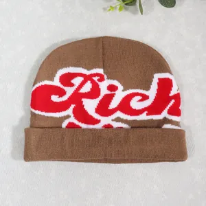 Close-up of brown knit beanie with red and white Rich lettering and folded cuff
