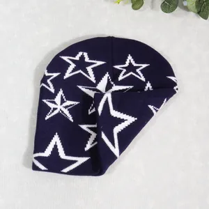Detalle del tejido de punto del gorro azul marino con patrones de jacquard de estrellas