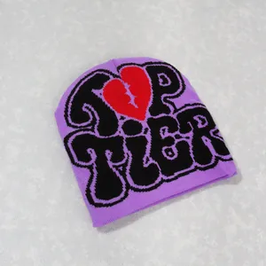 Flat lay of purple Y2K beanie with black TOP TIER text and red broken heart pattern