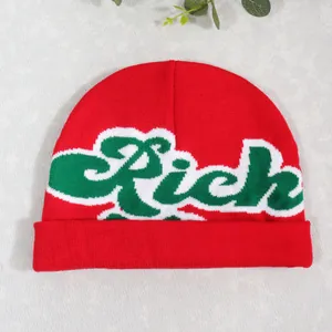 Detail of red knit beanie with green Rich embroidery and wide folded cuff design