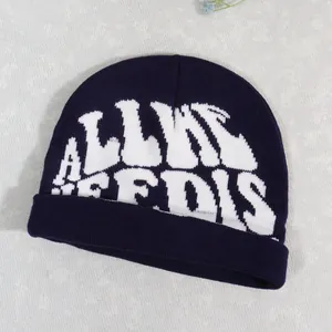 Close-up of dark blue knit beanie with white jacquard street style letter pattern