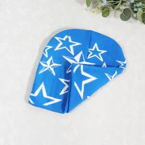 Detalle de gorro de punto azul cielo con estrellas blancas y textura suave al tacto
