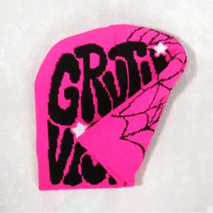 Detailed knit texture of a pink beanie with black spider web and gothic letters