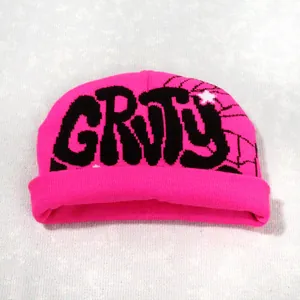 Detail of pink knitted beanie with black GRTI jacquard text and spider web pattern