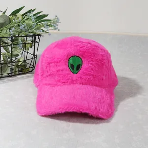 Close-up of fluffy pink plush baseball cap with green alien head embroidery patch