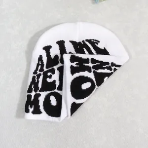Detail shot of the thick knitted beanie fabric showing the black letter jacquard pattern