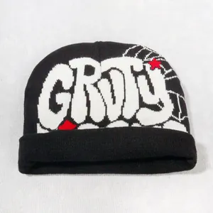 Detail of knitted beanie with graffiti-style GROU letters and red star embroidery