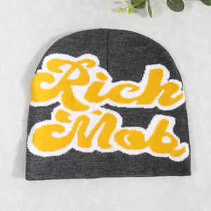 Detailed knit texture of dark gray beanie with yellow Rich Mob embroidered letters