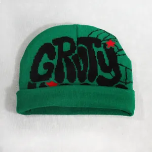 Detail of dark green ribbed knit beanie with black GRITY graffiti and red stars