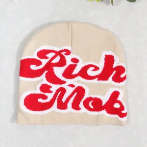 Beige knit beanie hat featuring bold red Rich Mob cursive embroidery and white outline
