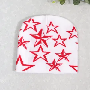 Detalle plano de un gorro de punto blanco con llamativos patrones de estrellas rojas