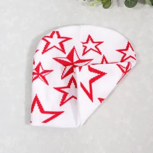 Detalle del gorro de punto blanco con estampado de estrella roja y textura suave y elástica