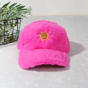 Détail de la casquette de baseball en peluche rose fluo avec broderie soleil jaune
