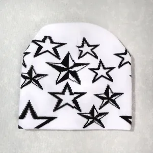 Detalle de la textura de punto del gorro Y2K blanco con estrellas negras y tejido grueso