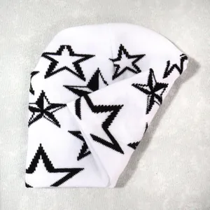 Primer plano detallado de un gorro de punto blanco con patrones de estrellas negras