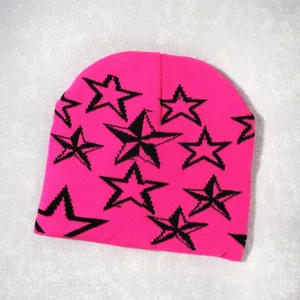 Detalle del gorro de punto rosa intenso con patrones de estrellas negras y tejido suave