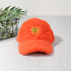 Détail de la casquette de baseball en peluche orange avec broderie de soleil jaune