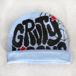 Detail of light blue knit beanie with black Groovy graffiti text and red star embroidery