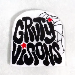 Close-up of white knit beanie featuring black gothic embroidery and red stars detail