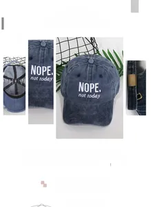 Detail of navy blue washed denim baseball cap with NOPE embroidery and metal buckle