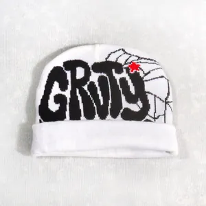 Close-up of white knitted beanie featuring black GRTS text and a small red star detail