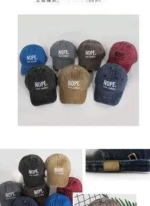 Detail of adjustable metal buckle and NOPE embroidery on washed cotton baseball caps