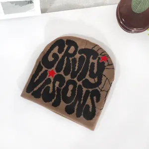 Detailed close-up of brown knit beanie featuring black graffiti lettering and red stars