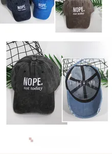 Close-up of NOPE embroidery on washed cotton baseball caps in various colors