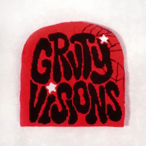 Detail of red knit beanie with GRTY VISONS lettering, spider web and star patterns