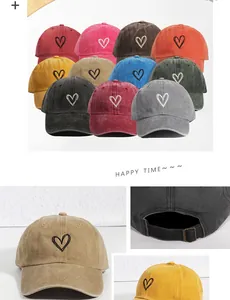 Close-up of overlapping heart embroidery and adjustable metal buckle on cotton baseball cap