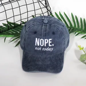 Vintage washed navy baseball cap featuring white NOPE embroidery in a minimalist style