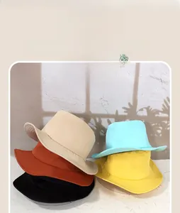 Close-up of stacked breathable cotton sun hats in beige, orange, black, blue and yellow