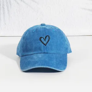 Breathable washed blue cotton baseball cap with embroidered heart on clean background