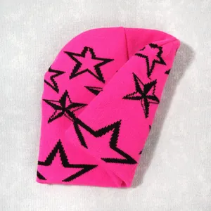 Detailed knit texture of pink star beanie with black jacquard star pattern on white cloth