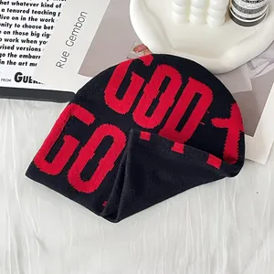 Street style black and red knitted beanie with bold letter patterns on artistic background