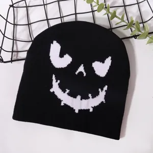 Halloween knitted beanie with white pumpkin face jacquard pattern on black acrylic fabric