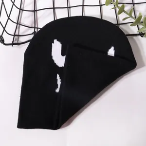 Halloween knitted beanie featuring white pumpkin jacquard smile on soft black fabric