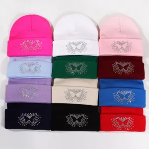 Collection of knitted beanies in various colors featuring sparkling rhinestone butterfly patterns