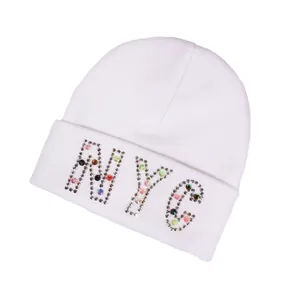 White knit beanie hat featuring NYC rhinestone lettering design in a slanted view