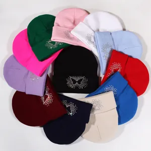 Knit beanies with rhinestone butterfly motif shown in multiple colors for winter fashion