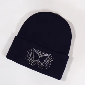 Dark blue knitted beanie featuring a colorful rhinestone butterfly on the folded brim