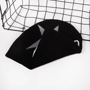 Close-up of black knit beanie featuring a grey star jacquard pattern on high-quality fabric