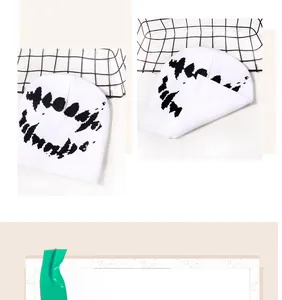 Dettaglio del berretto in maglia bianco con motivo a denti neri per stile street