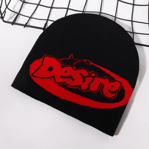 Detailed knit texture of a black beanie with red Desire lettering and jacquard patterns